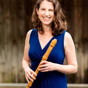Anne Timberlake, holding her recorder in a casual outdoor setting.