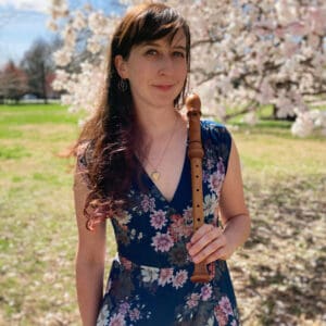 Rachel Siegel holding her recorder in a casual and sunny green space.