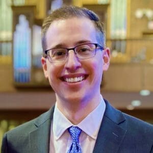 Matthew Gerhardt, smiling in a suit and tie.