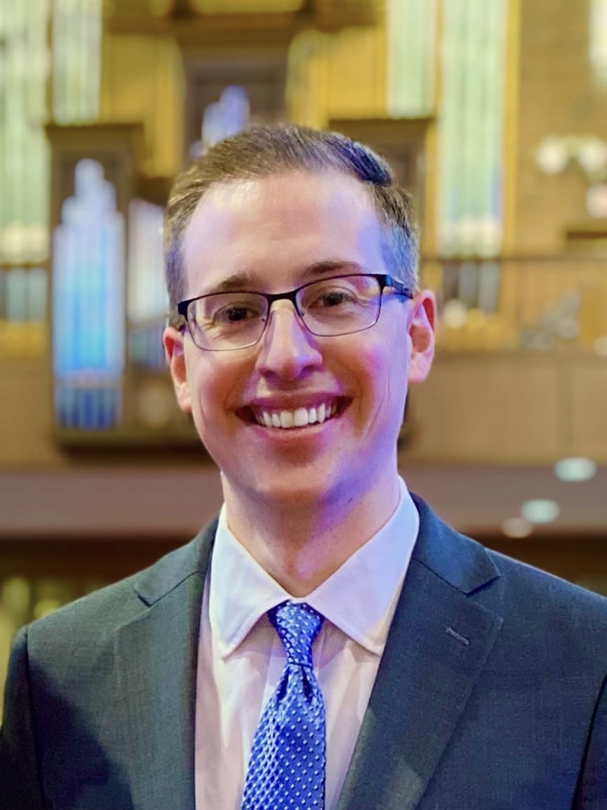 Matthew Gerhardt, smiling in a suit and tie.